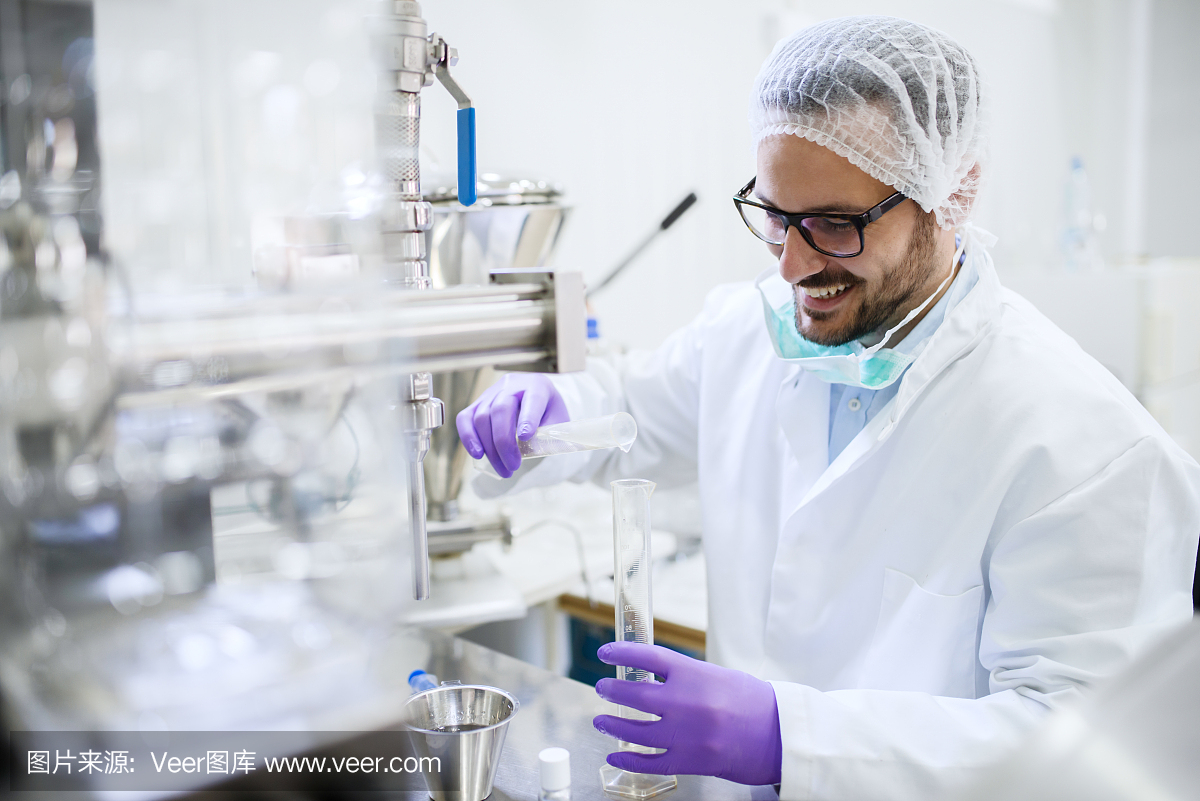 微笑的化学家站在实验室里往试管里倒水。水质检查概念。